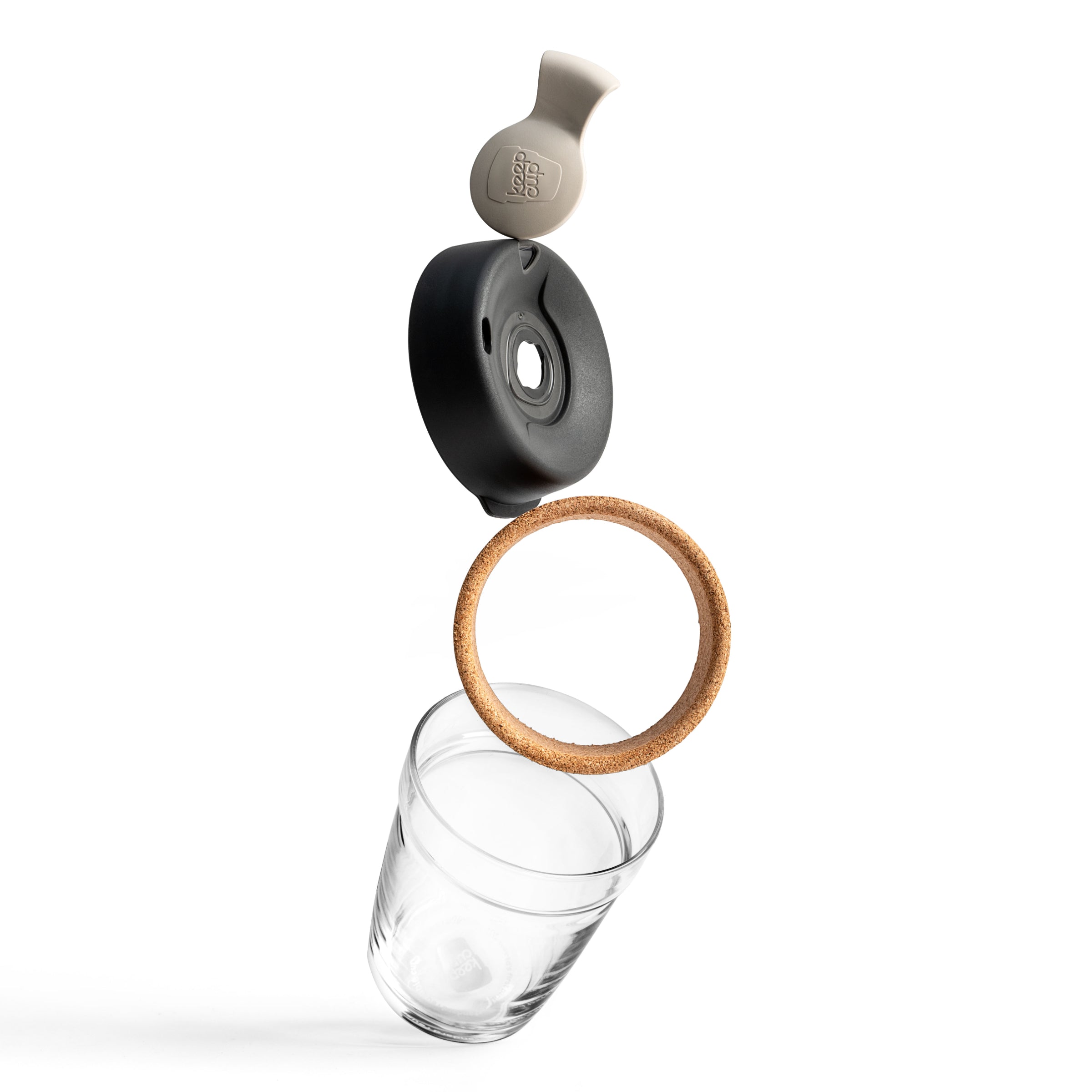 Exploded view of reusable glass water bottle with cork ring, black lid and grey silicone stopper floating above clear glass base