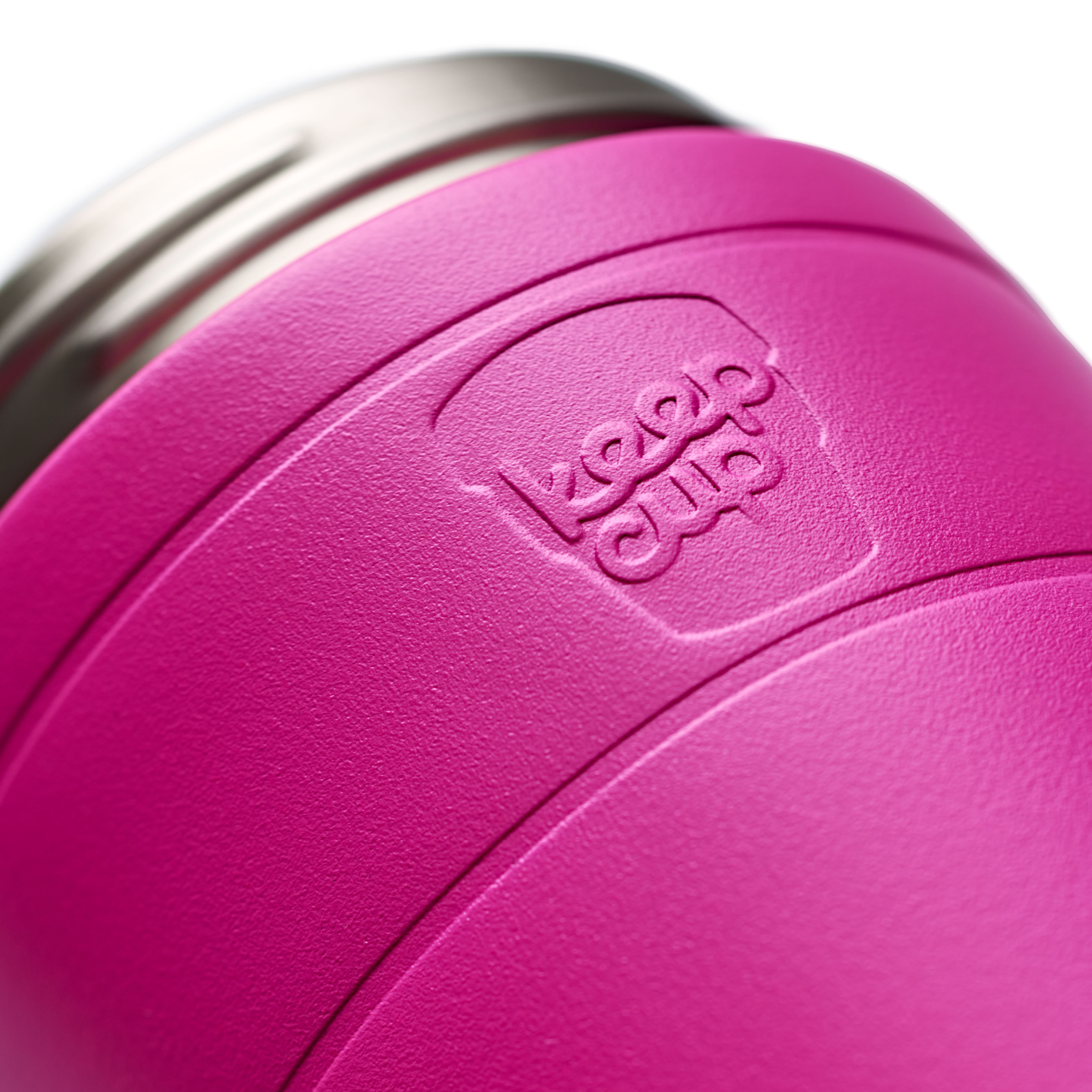 Close-up of a bright pink vacuum-insulated KeepCup tumbler with a stainless steel rim and an embossed brand logo on the side.