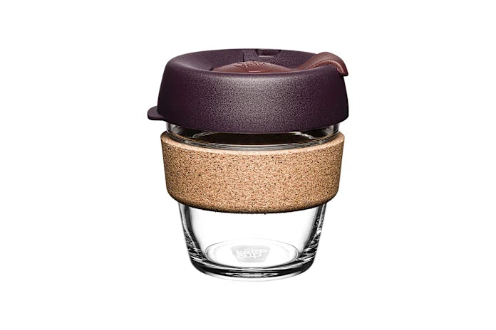 Reusable glass coffee cup with cork band and burgundy lid, eco-friendly travel mug on white background