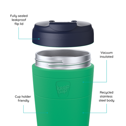 A green KeepCup travel tumbler with a dark navy flip lid, shown with callout lines and text labels highlighting features like a fully sealed leakproof flip lid, vacuum insulation, recycled stainless steel body, and cup holder friendliness.