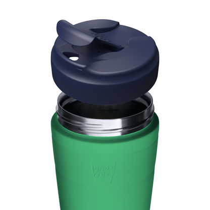 A close-up of a green insulated KeepCup travel tumbler with a dark navy blue flip-top lid, shown against a plain white background.