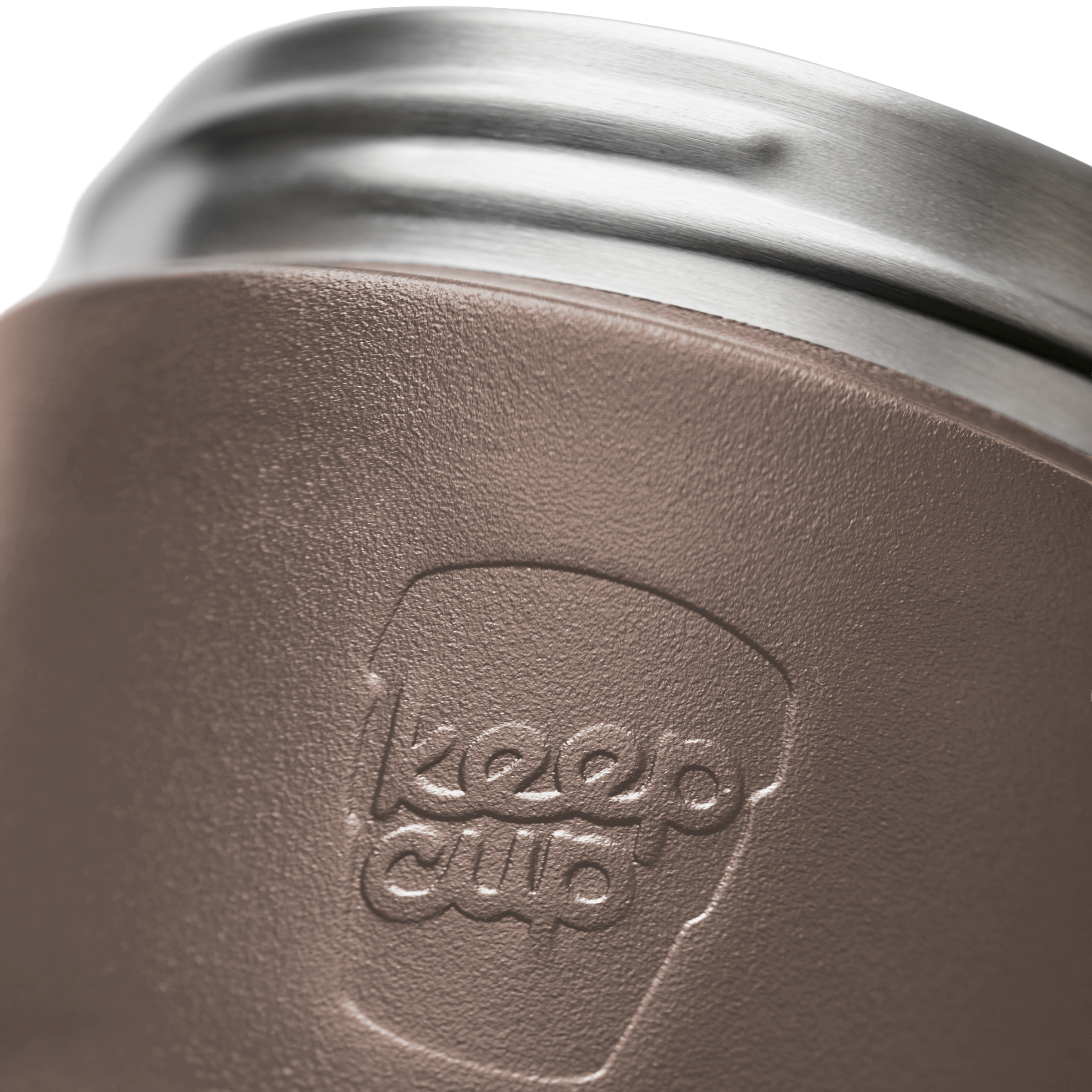 Close-up of a KeepCup insulated tumbler showing the embossed keep cup logo on a textured brown sleeve, with a stainless steel rim visible at the top.