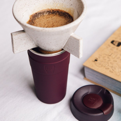 Coffee pour over in a maroon stainless steel KeepCup on a light surface