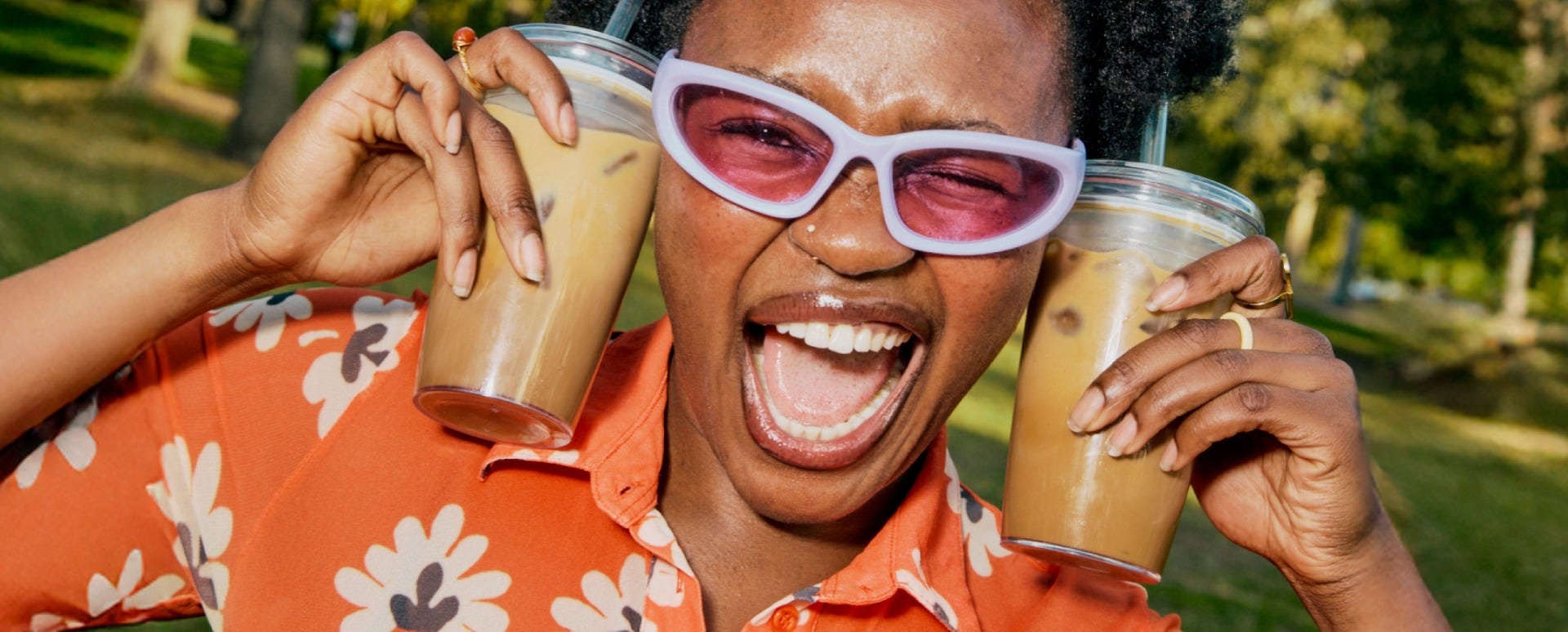 Woman holding KeepCup Sip & Chill Original Clear reusable cup with coffee and iced tea