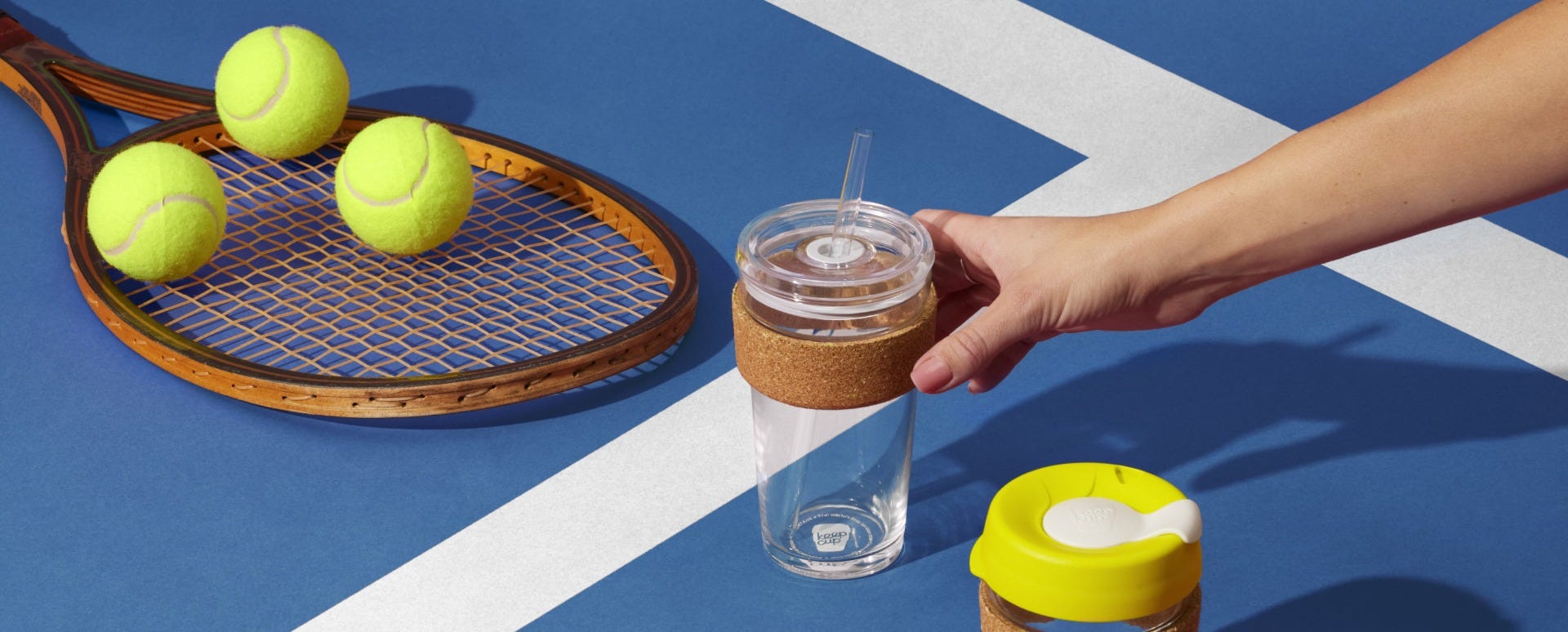 Woman holding KeepCup Cold Cup Cork Ace 16oz on tennis court